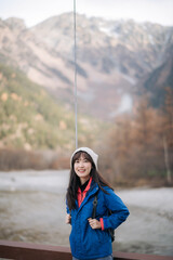 Enjoying the journey, Asian woman in a blue jacket stands alone by the lake. A stylish traveler in Japan, capturing the essence of freedom and exploration.