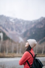 Nature's elegance, Asian woman in a pink fleece enjoys a snowy adventure. Elegant portrait by the...