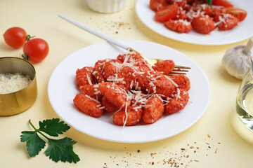Plates of tasty gnocchi with cheese on yellow background