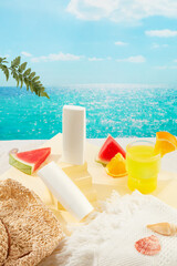 Front view of two tubes of sunscreen without labels, shells, fresh fruit, a white towel, a straw hat and a glass of juice on the sand. Simulated seascape.