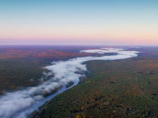 Aerial view of river in the forest on the foggy sunrise