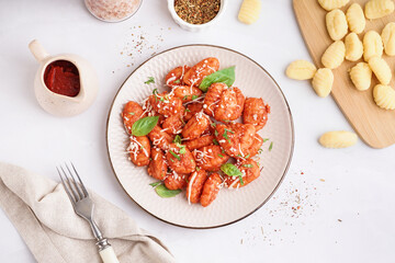Plate of tasty gnocchi with cheese on white background