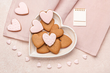Plate with sweet heart shaped cookies on pink background