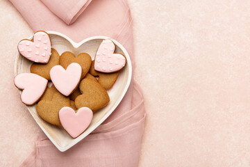 Plate with tasty heart shaped cookies on pink background