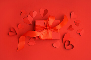 Beautiful composition with paper hearts and gift box on red background. Valentine's Day celebration