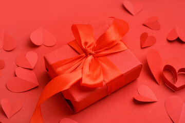 Beautiful composition with paper hearts and gift box on red background. Valentine's Day celebration