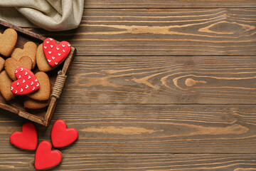 Tray with tasty heart shaped cookies and tablecloth on wooden background. Valentine's Day celebration