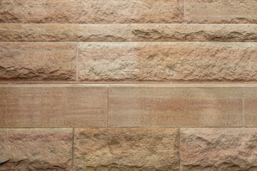 Full frame abstract texture background of a 19th century beige color textured limestone block wall