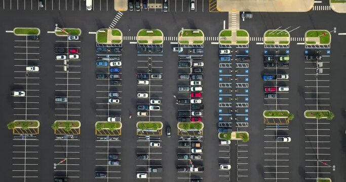 Cars parked on parking lot with lines and markings for parking places and directions. Place for vehicles in front of a grocery mall store