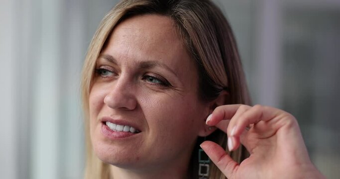 Woman plugs ear with finger and itchy ear