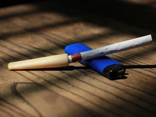 ciggaret and ivory pipe on wooden table