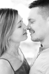 Smiling man and woman almost kiss with their eyes closed. Black and white photo