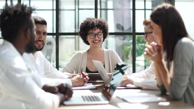 Employees working at computer together, discussing content