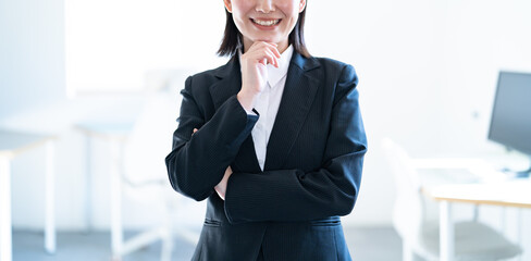 考えるスーツを着た日本人女性