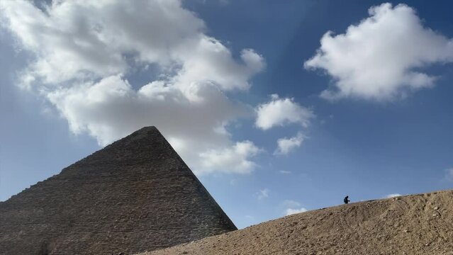 Great pyramid of Gyza in Egypt. Wide angle, nadir shot of tourist walks beside pyramid. slow motion