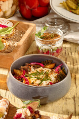 Salad with roasted potatoes, pulled beef, onions, and smoked sour cream in a rustic bowl