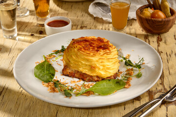 Meat topped with baked mashed potatoes, a Slavic-style potato casserole dish