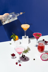 An action shot of tequila being poured into a frothy margarita cocktail, set in a dynamic blue and...