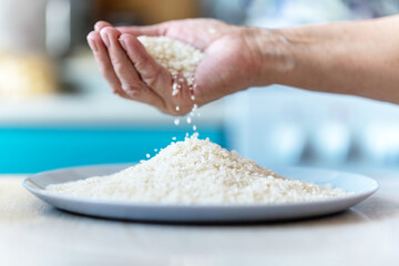 woman's hands holding jasmine rice, rice falling from hands, healthy and organic concept. top view