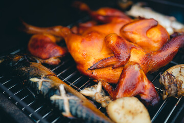 Homemade chicken rotisserie with thyme, Horizontal top view from above of fire oven, outdoor grilling food