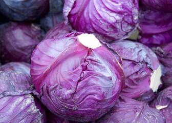 Close up on purple cabbage heads on display at Farmer's Market. Purple cabbage, also referred to as red cabbage, belongs to the Brassica genus of plants.