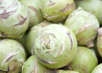 Close up on a pile of Kohlrabi, also called German turnip or turnip cabbage, is a biennial vegetable, a low, stout cultivar of wild cabbage. Displayed for sale at Farmer's Market.