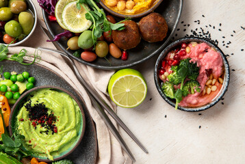 Vegan tasty hummus, herb hummus, beetroot hummus on a light wood background.
