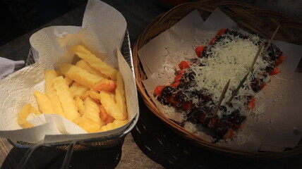 snacks are served on the table, potatoes and fried bananas sprinkled with cheese