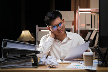 Fototapeta na wymiar Asian businessman overtime work and feel shoulder pain in the office.