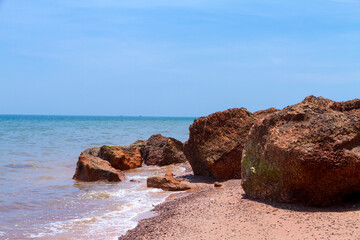 Fototapeta na wymiar Red stone and nature on beach