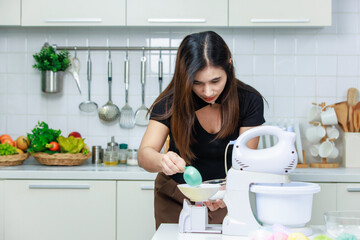 Asian beautiful professional female chef cooker housewife standing mixing flour and water in bowl...