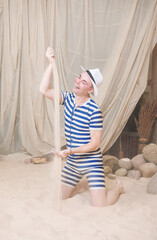 Funny man in vintage style striped swimsuit hold sand to sprinkle