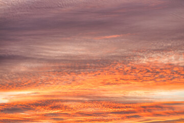 A beautiful sky tinted by the sun leaving vibrant shades of gold, pink, blue and multicolored. Clouds in the twilight evening and morning sky. Cloudy sky background in the evening and during the day.