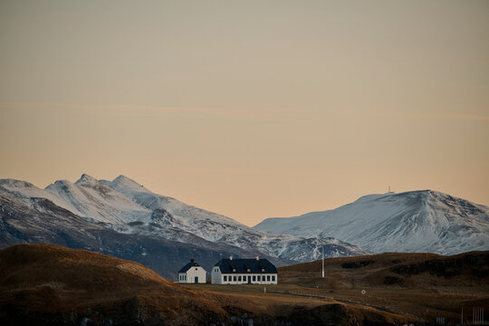 House surrounded by snowy mountains on island