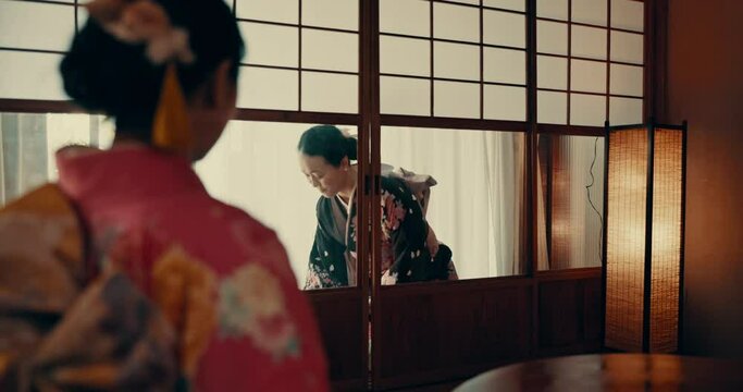 Women in traditional Japanese tea house, kimono and relax with mindfulness, respect and service. Woman at calm tearoom with drink on tray, zen culture and connection sitting at table for wellness.