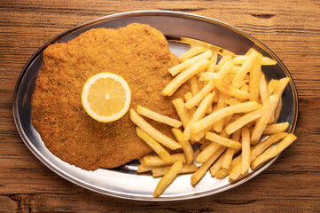 Overhead view of a plate of Milanese with French fries
