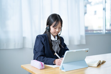 ヘッドセットをつけて学習をする学生服を着た女の子