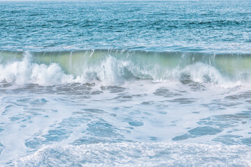 Wave splashes close-up. Crystal clear sea water hitting rock formations in the ocean in San Francisco Bay, blue water, pastel colors.