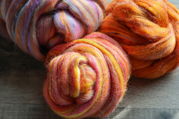 Closeup detail of colourful sheep wool merino, alpaca and silk fibres in a roving pleat, ready for...