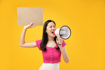 Portrait of a young Asian woman shouting angrily using a megaphone and holding paper. Isolated on a...