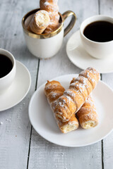 tubes with cream and coffee. on a wooden background. dessert