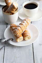 tubes with cream and coffee. on a wooden background. dessert