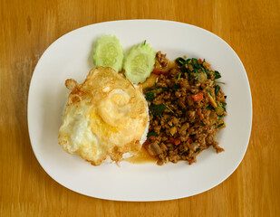 Thai stir fried basil with minced pork and fried egg eating with cooked rice, Thai food (Pad Kaprao Moo Kai Dao)