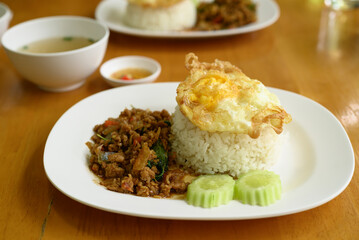 Thai stir fried basil with minced pork and fried egg eating with cooked rice, Thai food (Pad Kaprao Moo Kai Dao)