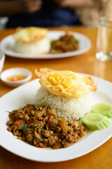 Thai stir fried basil with minced pork and fried egg eating with cooked rice, Thai food (Pad Kaprao Moo Kai Dao)