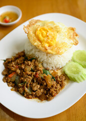 Thai stir fried basil with minced pork and fried egg eating with cooked rice, Thai food (Pad Kaprao Moo Kai Dao)