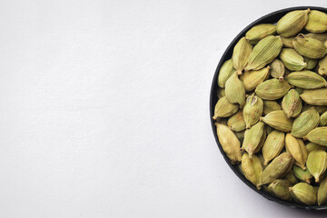 Healthy green cardamom kept on a white background.