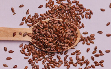 Flax seeds kept on a white background on a wooden spoon