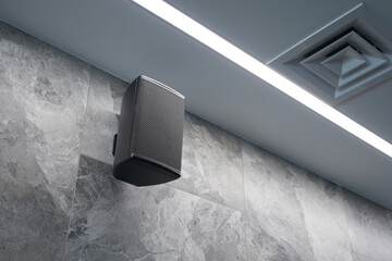 Black wall speaker installed in building sound system