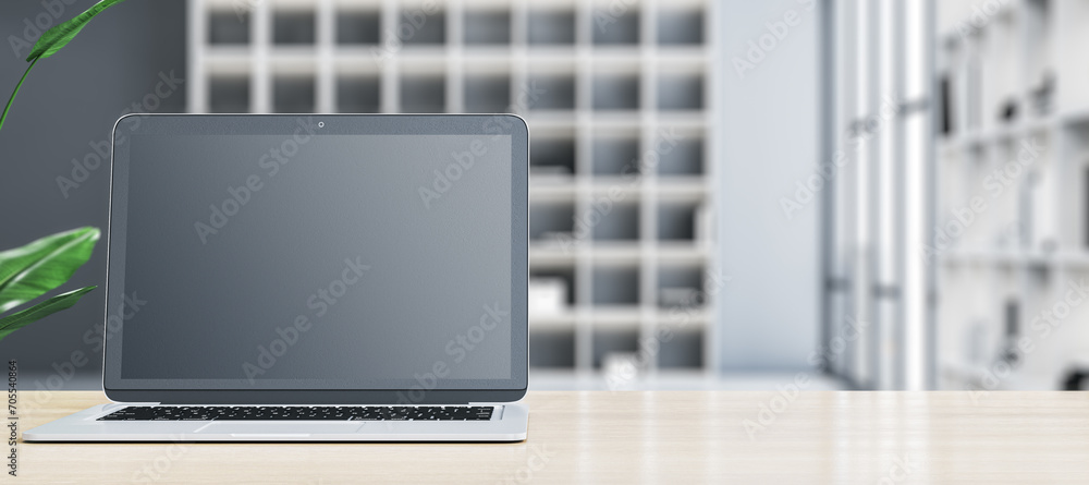 Poster modern designer office desktop with empty mock up laptop screen and other items on wide blurry offic